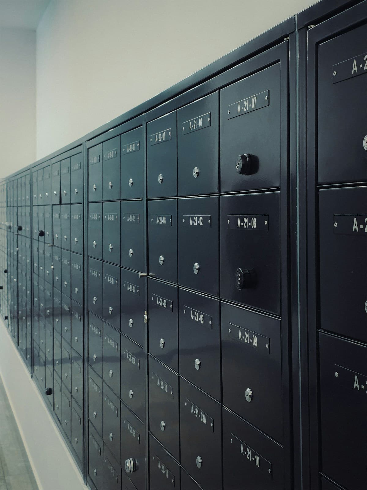 A wall of numbered dark metal mailboxes