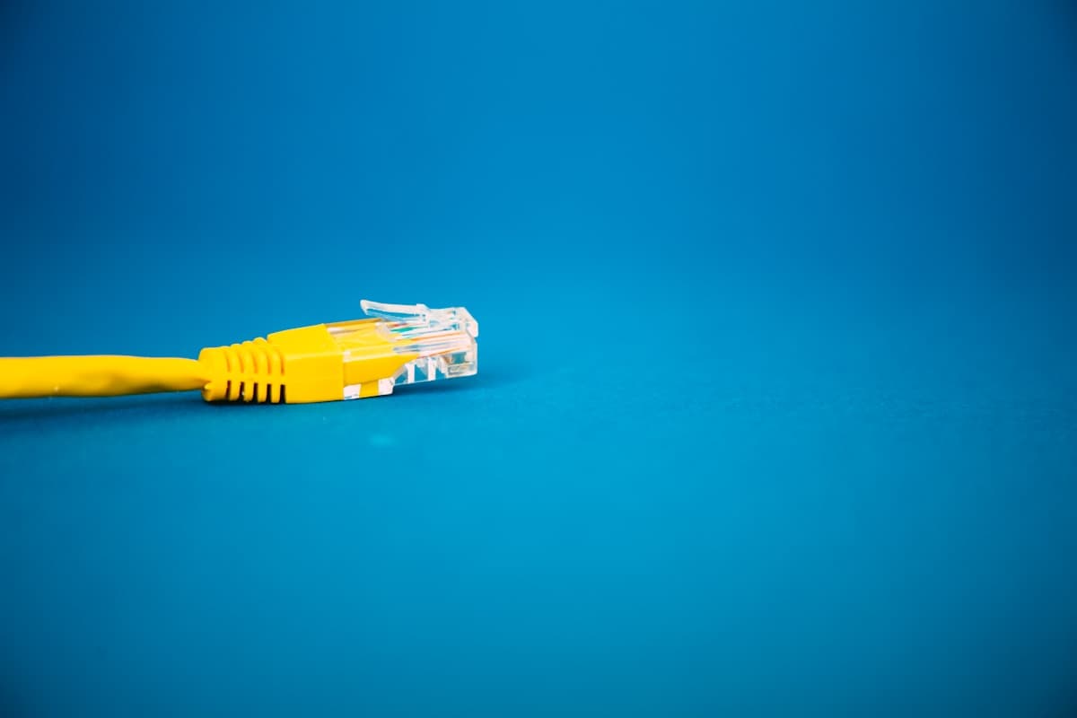 An unplugged yellow network cable on a blue background